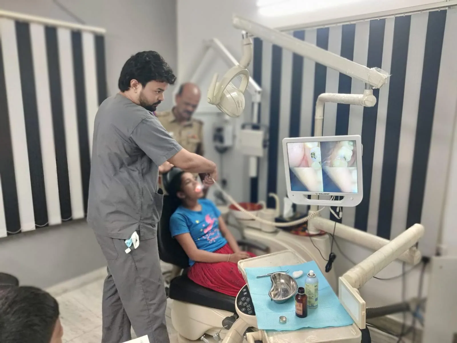 A child being treated at the clinic, a parent close by.